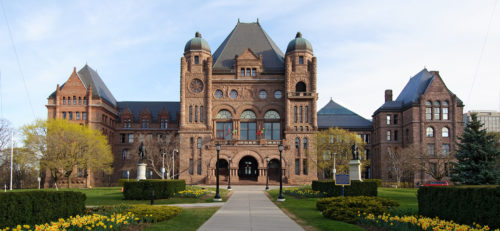 An ornate building with bushes in front of it.